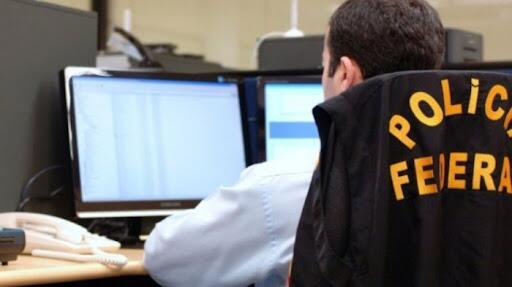 Policia federal sentado na frente computador